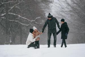 Front view. Happy, family, is outdoors, enjoying snow time at winter together photo
