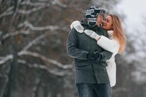 Embracing each other. Lovely couple are together, enjoy,ing walk outdoors at winter season photo