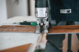 Cutting the ,planks. Man is ,installing new laminated wooden floor photo