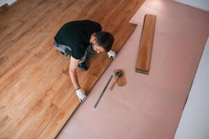 Top ,view.. Man is installing new laminated wooden floor photo