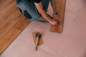 Close, up ,view. Man is installing new laminated wooden floor photo
