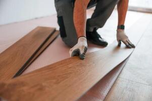 Close up, view. Man is, installing new laminated wooden floor photo