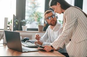 Showing ,information on ,tablet. Two employees are working together in the modern office photo