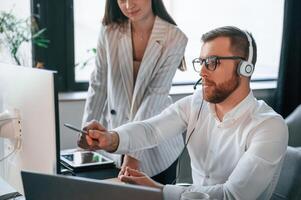 Analyzing ,information that is ,on the screen. Two employees are working together in the modern office photo