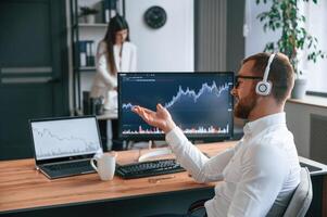 Exchange ,graphs on the screen. Two employees are working together in the modern office photo