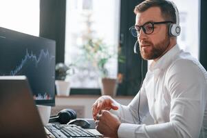 Stock ,exchange, graphs on the screen. Man in formal clothes is working in the modern office. Using computer photo