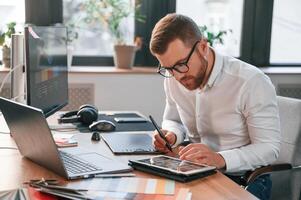 Using tablet. Man in formal ,clothes is working in the modern office photo