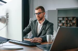 Businessman, in suit is in the office with computer photo
