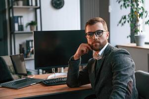 Businessman ,in suit is in the office with computer. photo