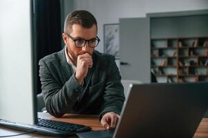 Businessman ,in suit i,s in the office with computer photo