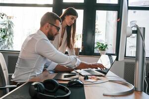 Two employees, are working together in the modern office photo