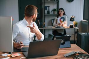 Designers, are talking and working. Two employees are together in the modern office photo
