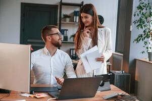 Designers ,are talking and working. Two employees are together in the modern office photo