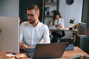 Two employees are ,working together in the modern office photo