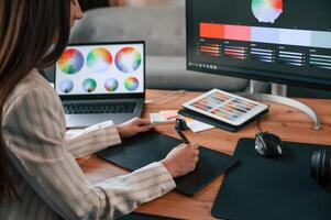 Drawing, by using graphic tablet. Woman is working in the modern office with computer photo