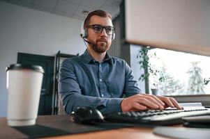 Typing ,on the keyboard. Man in formal clothes is working in the modern office. Using computer photo