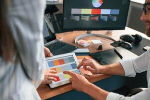 Two employees are working together in the modern office photo