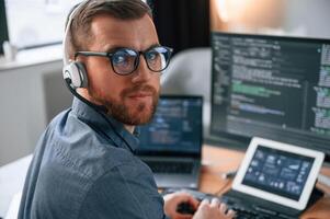 Software developer ,is ,writing code. Man in formal clothes is working in the modern office. Using computer photo