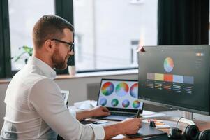 Man ,in formal, clothes is working in the modern office. Using computer photo