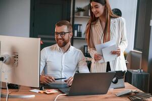 Designers are talking and ,working. Two employees are together in the modern office photo