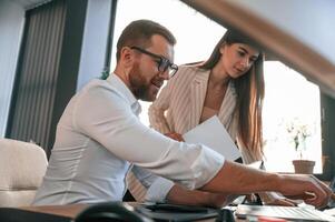 Side view. Paper work. Two employees are together in the modern office photo
