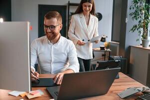 Designers are talking and, working. Two employees are together in the modern office photo