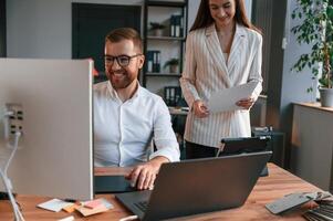 Designers are, talking and working. Two employees are together in the modern office photo