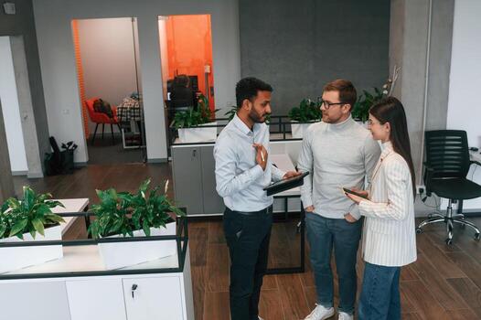 Standing, and talking. Couple are in the office, getting consulted by a manager photo