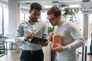 Two men, are working in the modern office together photo