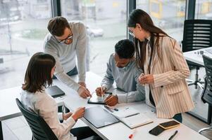 Conception, of brainstorming. Four people are working in the office together photo