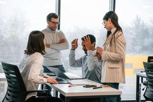 Having ,the meeting. Four people are working in the office together photo