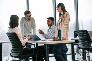 Conception of, brainstorming. Four people are working in the office together photo