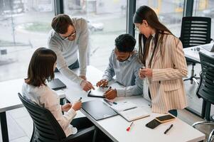 Conception of brainstorming.. Four ,people are working in the office together photo