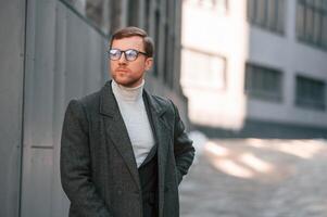 Portrait, of handsome man that is in formal clothes is outdoor near the business building photo