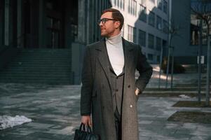 Standing near business, building. Handsome man in formal clothes is outdoor photo