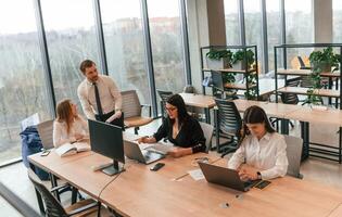 Sitting by, the table. Business people in formal clothes are working in the office together photo