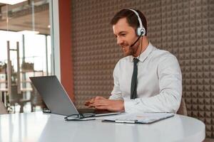 Using laptop.. Handsome man in formal clothes is in the office photo