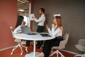 Manager is showing the plan project. Three business, people are working in the office together photo