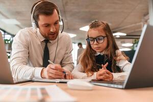 Man is helping, teaching., Little girl is in the office where people working together photo