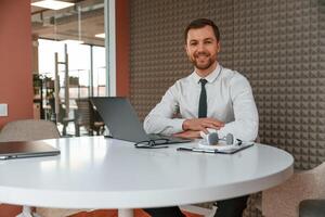 Handsome ,man in formal clothes is working by laptop in the office photo