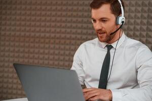 Using, laptop.. Handsome man in formal clothes is in the office photo