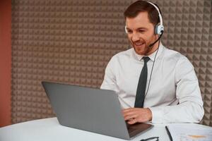 Using laptop. Handsome man ,in formal clothes is in the office photo