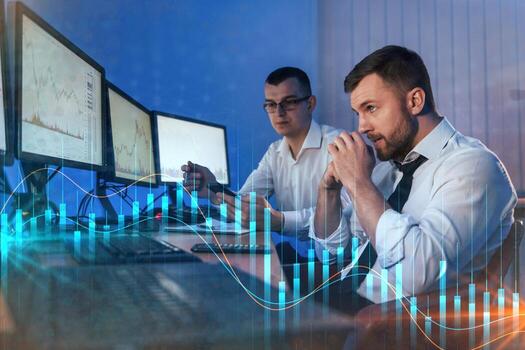 Graphs and data. Different information on screens. Two stock traders working in the office with exchange technology photo