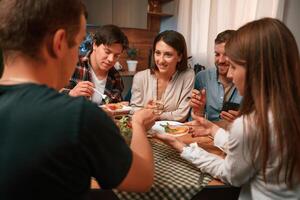 Delicious food.. Group of people are on the kitchen, having dinner, spending time together photo