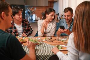 Delicious food. Group, of people are on the kitchen, having dinner, spending time together photo