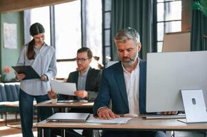 Using computer. Group, of business people are working in the modern office photo