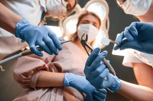 Three, doctors are working. First person view. In the stomatological cabinet photo