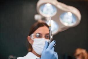 Woman holding ,syringe. In the, stomatological cabinet photo