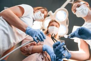 Three doctors are working., First person view. In the stomatological cabinet photo