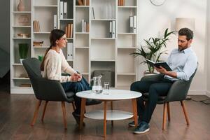 A session, with ,a ,psychologist. With woman. Doctor in formal clothes is working in the cabinet photo